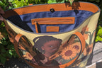 Flower Girl Tote - Vegan Leather Bag | Wearable Art featuring a smiling girl with sunflowers, brown handles, and interior zip pocket.